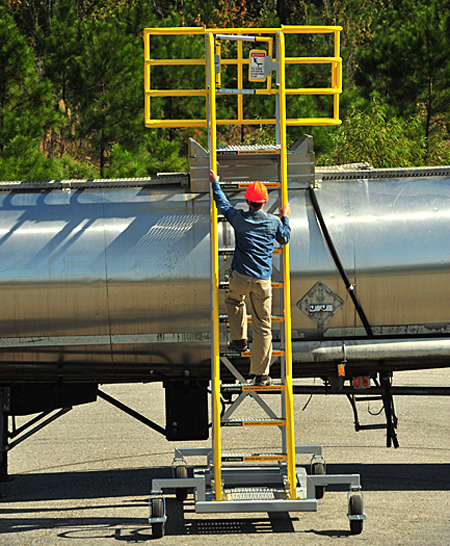 Rear view of Cantilever Mobile Work Platform with optional safety cage as worker climbs stairs
